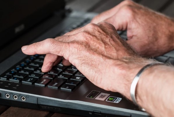 Hombre escribiendo en ordenador portatil