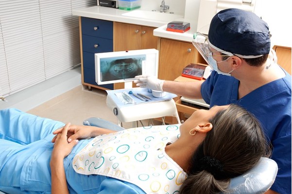 Dentista enseñando radiografia de dientes a paciente