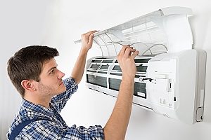 54191066 - young male technician cleaning air conditioning system at home