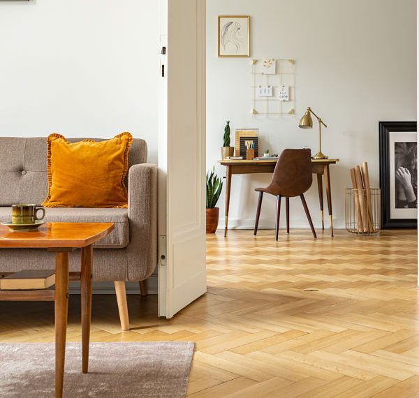 Real photo of a retro living room interior and view of a home office. View through a door